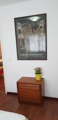 a painting hanging on a wall above a wooden dresser at Migjorn Apartment a place in the heart of Sitges in Sitges