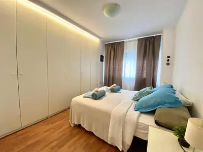 a bedroom with a bed with blue pillows on it at Migjorn Apartment a place in the heart of Sitges in Sitges