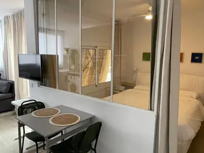 a room with a table and a bed and a mirror at Baetulo III in Badalona