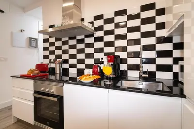 a kitchen with a black and white checkered wall at Charming Seaside Apartment in Barceloneta, Renovated with Stunning Sea Views in Barcelona