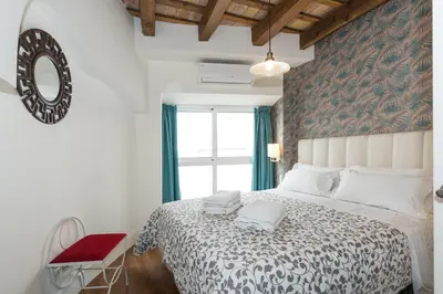 a bedroom with a large bed and a window at Apartamentos Mayor by Habama Group in Sitges