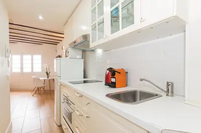 a kitchen with white cabinets and a sink at Apartamentos Mayor by Habama Group in Sitges