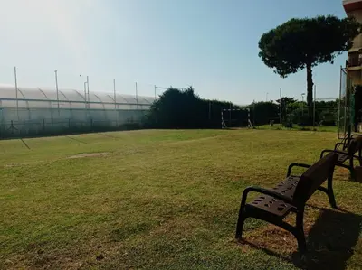 a park bench in a field with a playground at Opening Doors Premiá Beach - Sol & playa cerca Barcelona in Premiá de Mar