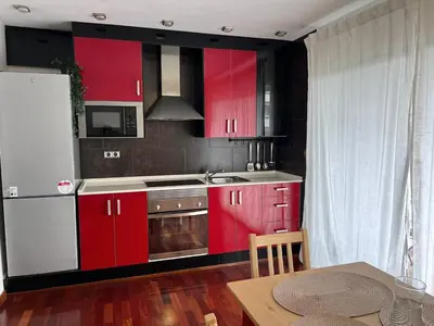 a kitchen with red cabinets and a table in a room at Opening Doors Premiá Beach - Sol & playa cerca Barcelona in Premiá de Mar