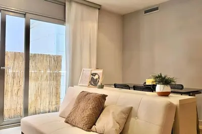 a living room with a white couch and a large window at Penthouse 100m from Sea with Terrace, Near BCN in Mataró