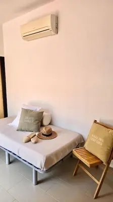 a room with a bed with a fan and a chair at Penthouse 100m from Sea with Terrace, Near BCN in Mataró