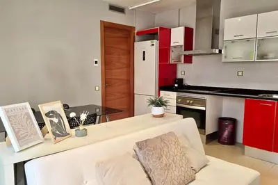 a kitchen with a white couch and red cabinets at Penthouse 100m from Sea with Terrace, Near BCN in Mataró