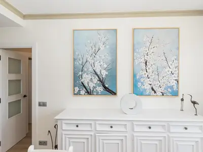two paintings on a wall above a white dresser at Sitges Spaces Seaside Paradise in Sitges