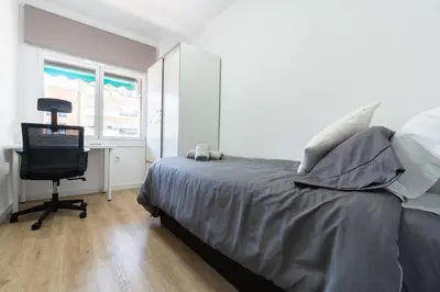 a bedroom with a bed and a desk and a computer at Apartamento Granollers in Granollers