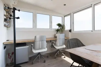 an office with a table and chairs and windows at Fantastic view penthouse apartment in Barcelona