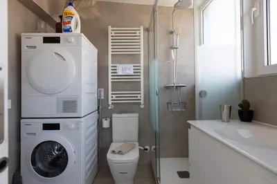 a bathroom with a washing machine and a toilet at Fantastic view penthouse apartment in Barcelona