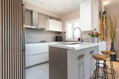 a white kitchen with white cabinets and a sink at Fantastic view penthouse apartment in Barcelona