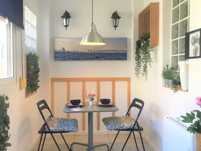 a table in a kitchen with two chairs and a pendant light at Best refuge in Barcelona in Sant Adria de Besos