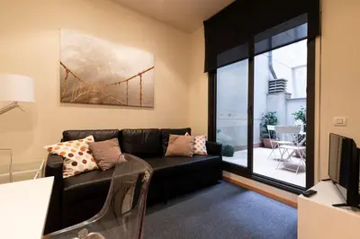 a living room with a black couch and a window at 2762 - AB Park Guell Apartment B-II in Barcelona