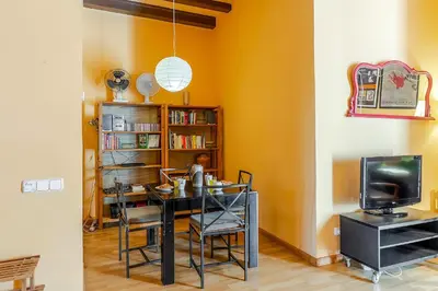 a dining room with a table and a tv at 4179 - AB Verdi Villa de Gracia Apartment in Barcelona