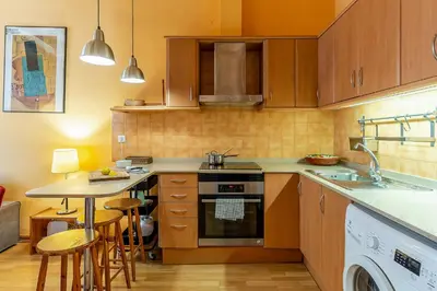 a kitchen with a stove and a sink and a table at 4179 - AB Verdi Villa de Gracia Apartment in Barcelona