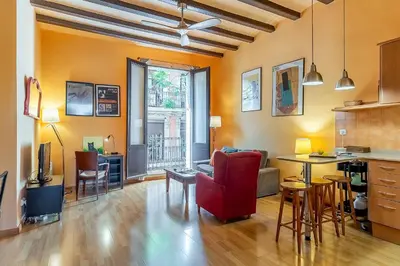 a living room with a red chair and a table at 4179 - AB Verdi Villa de Gracia Apartment in Barcelona