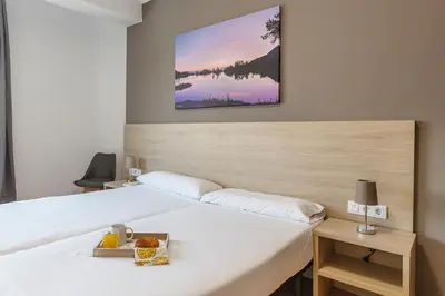 a bedroom with a large white bed with a picture on the wall at 4254 - AB Sagrada Familia Views III-II in Barcelona