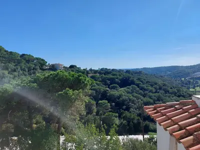 a view of a house in the middle of trees at Can Loïs in Sant Cebrià de Vallalta