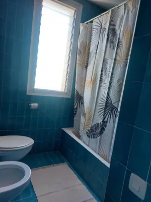 a blue bathroom with a toilet and a shower curtain at Can Loïs in Sant Cebrià de Vallalta