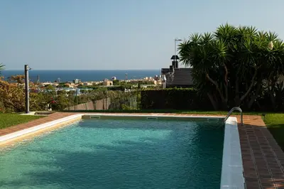 a swimming pool with blue water in a yard at Sea View Villa with Spa & BBQ in Badalona