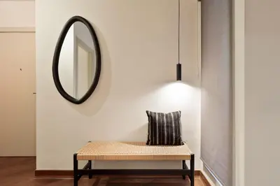 a mirror on a wall next to a bench with a pillow at Enjoy Apartments Urban Retreat Valencia 4 in Barcelona