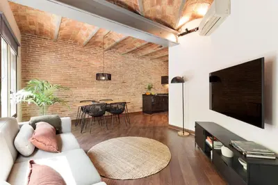 a living room with a white couch and a brick wall at Enjoy Apartments Urban Retreat Valencia 4 in Barcelona