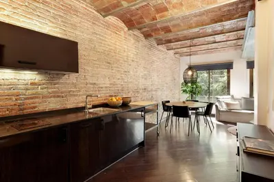 a kitchen and dining room with a brick wall at Enjoy Apartments Urban Retreat Valencia 1 in Barcelona
