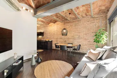 a living room with a couch and a brick wall at Enjoy Apartments Urban Retreat Valencia 1 in Barcelona