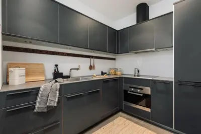 a kitchen with black cabinets and a sink at Zamora - 3 bedrooms in Eixample Esquerra in Barcelona