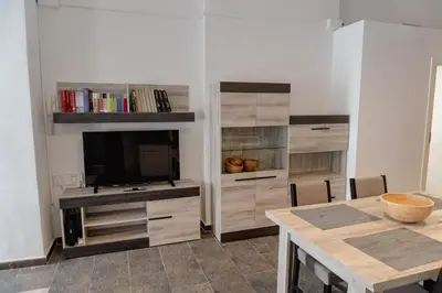 a living room with a television and a dining room table at Full 50sqm Loft in Badalona in Badalona
