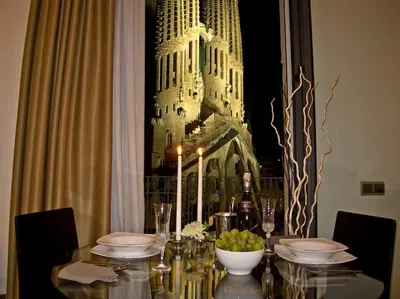 a dining room table with a bottle of wine and a building at Flat with views to Sagrada Famila in Barcelona