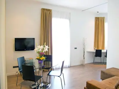 a living room with a table and chairs and a television at Flat with views to Sagrada Famila in Barcelona