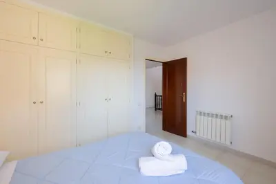 a bedroom with a large bed with towels on it at Casa Nina junto Barcelona Centro y playa in Teià