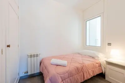 a white bedroom with a bed with a towel on it at Casa Nina junto Barcelona Centro y playa in Teià