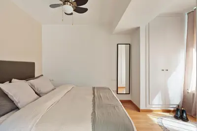 a bedroom with a large bed with a ceiling fan at Cerca de la Playa y El Born, con Piscina in Barcelona