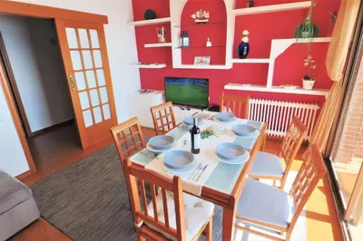 a dining room with a table and chairs and red walls at Carmen Seaview & Beach - Apartment in Montgat