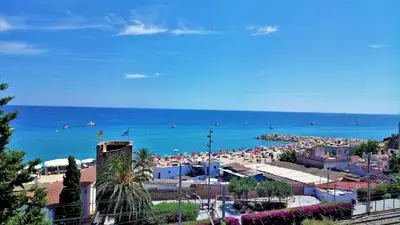a beach with a lot of people and the ocean at Carmen Seaview & Beach - Apartment in Montgat