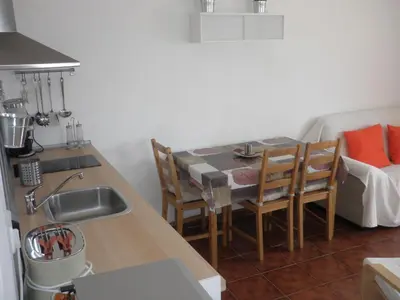 a kitchen with a table and chairs and a sink at Apartament Can Batlle in Premiá de Mar