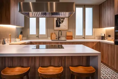 a kitchen with a island with two stools in it at Lovely 6 BR Flat in L'Eixample in Barcelona