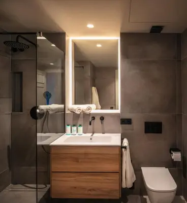 a bathroom with a sink and a toilet and a mirror at Lovely 6 BR Flat in L'Eixample in Barcelona