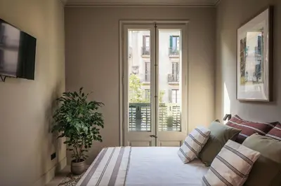 a living room with a bed and a window at Lovely 6 BR Flat in L'Eixample in Barcelona