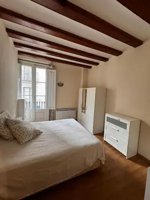 a bedroom with a white bed and a white refrigerator at Habitacion Privada en APARTAMENTO COMPARTIDO in Barcelona