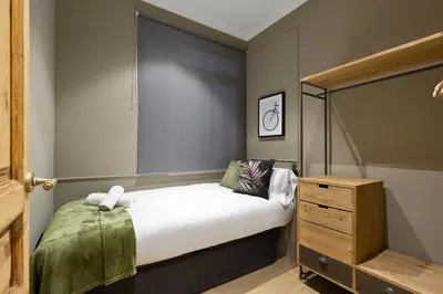 a small bedroom with a bed and a wooden dresser at Sagrada266 by chicStays in Barcelona