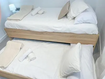 two beds with white sheets and pillows on them at Elegancia y confort en Casa Moncerrat in Vilanova i la Geltrú