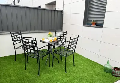 a table and chairs on a patio with grass at Elegancia y confort en Casa Moncerrat in Vilanova i la Geltrú