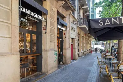 an empty street with tables and chairs outside a store at Canela Homes BARCELONA BRUC in Barcelona