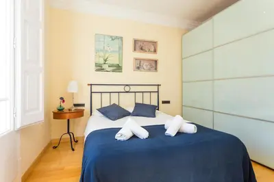 a bedroom with a bed with blue sheets and white pillows at Charming Central Apartment Big Sunny Terrace! in Barcelona
