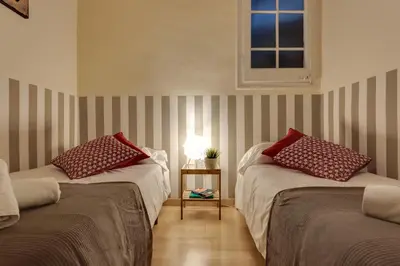 two beds in a room with striped walls at Charming Central Apartment Big Sunny Terrace! in Barcelona