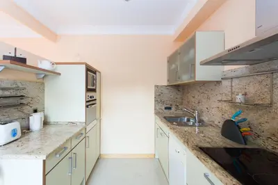 a kitchen with white cabinets and marble counter tops at Charming Central Apartment Big Sunny Terrace! in Barcelona